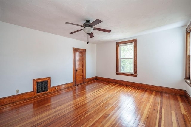 empty room featuring a ceiling fan, baseboards, and light wood-type flooring