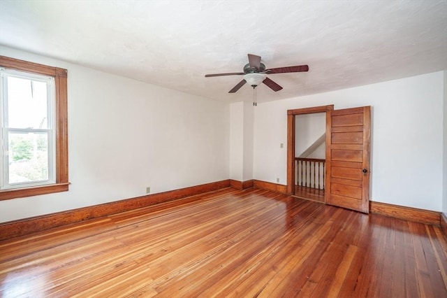 empty room with baseboards, hardwood / wood-style floors, and ceiling fan
