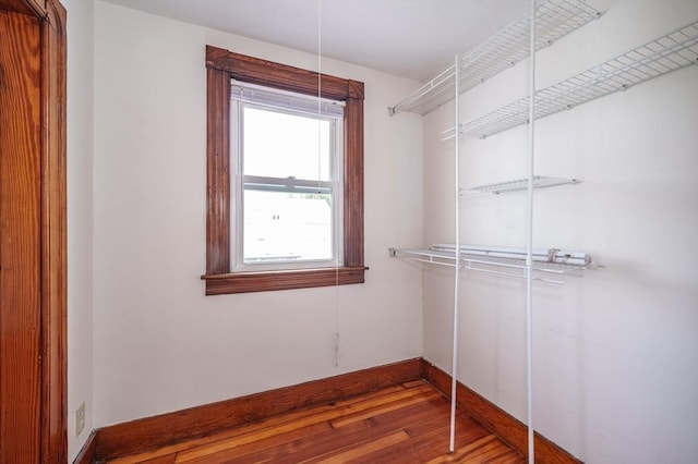 walk in closet with wood finished floors
