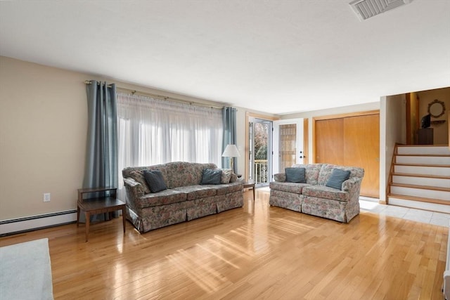 living room featuring a baseboard radiator, visible vents, stairway, and light wood-style flooring