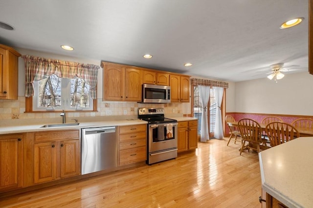 kitchen featuring a healthy amount of sunlight, stainless steel appliances, a sink, and light countertops