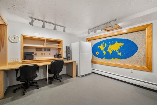 home office featuring a textured ceiling, built in study area, and finished concrete flooring