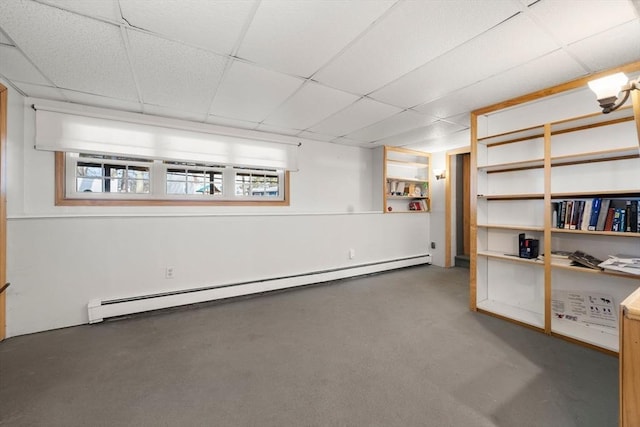 basement with a drop ceiling and a baseboard radiator