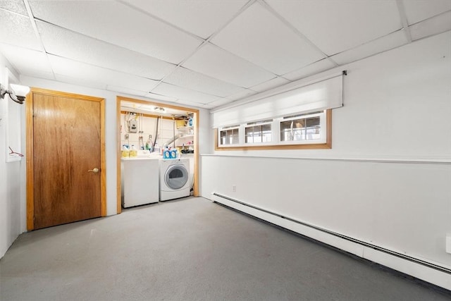 basement featuring washer and clothes dryer, a baseboard radiator, and a paneled ceiling