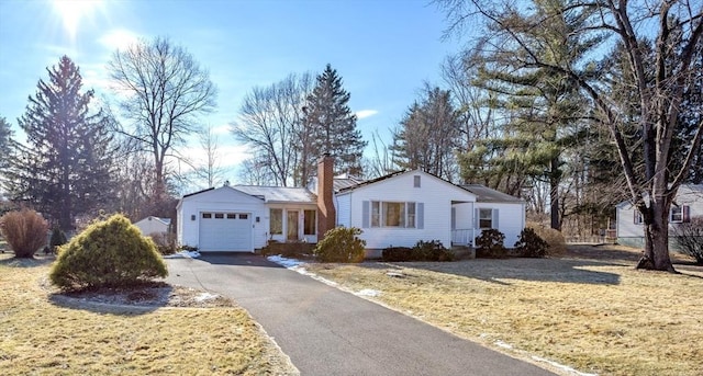 ranch-style house featuring a garage and a front lawn