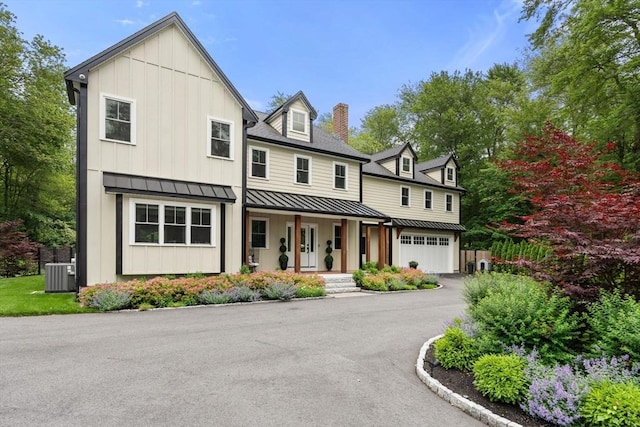 35 E St, Middleton, MA 01949 - view of front of property featuring covered porch, a chimney, a standing seam roof, board and batten siding, and asphalt driveway