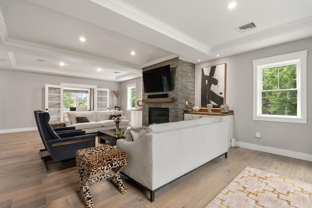 35 E St, Middleton, MA 01949 - living area featuring ornamental molding, a stone fireplace, wood finished floors, a tray ceiling, and recessed lighting