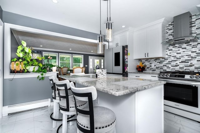 kitchen featuring white cabinetry, marble finish floor, appliances with stainless steel finishes, baseboard heating, and wall chimney range hood