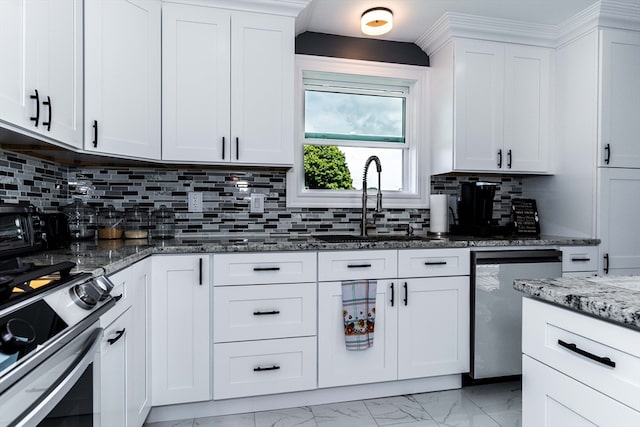 kitchen with appliances with stainless steel finishes, white cabinetry, and backsplash