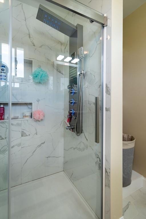 full bath featuring marble finish floor and a marble finish shower