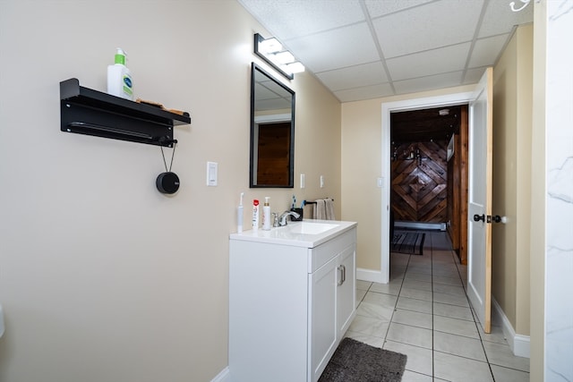 bathroom with vanity, a paneled ceiling, and tile patterned floors