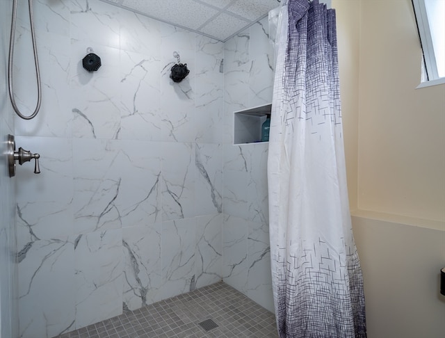 bathroom with a shower with curtain and a drop ceiling