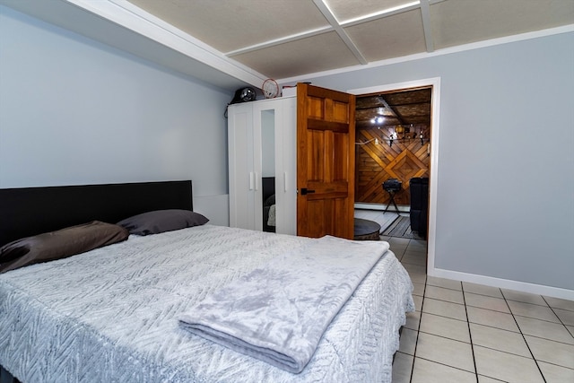 bedroom with wooden walls and light tile patterned flooring