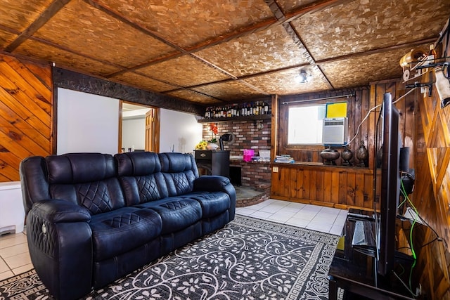 living room featuring a wood stove, wooden walls, and tile patterned floors