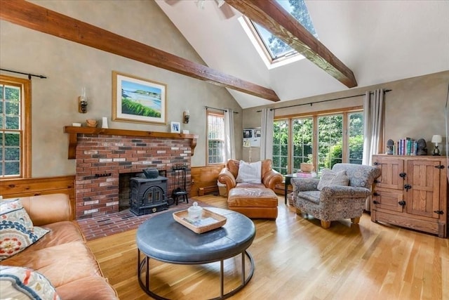 11 Tara Dr, Pembroke, MA 02359 - living area with a wood stove, a skylight, wood finished floors, high vaulted ceiling, and wainscoting