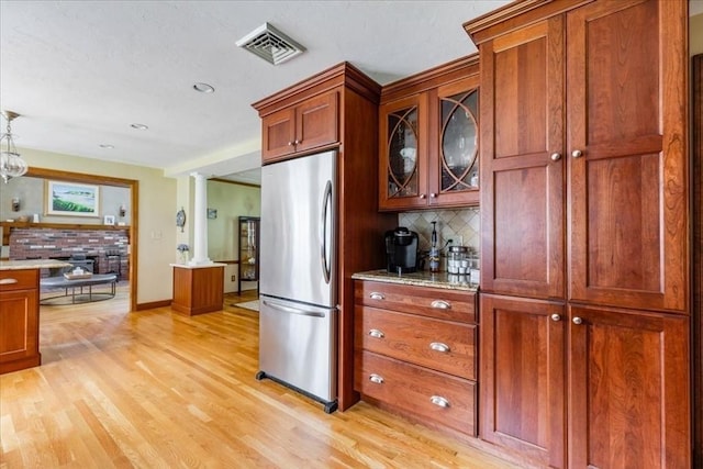 11 Tara Dr, Pembroke, MA 02359 - kitchen with freestanding refrigerator, backsplash, light wood-style flooring, brown cabinetry, and glass insert cabinets