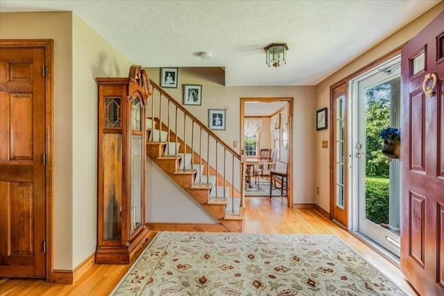 11 Tara Dr, Pembroke, MA 02359 - foyer entrance with light wood finished floors, stairs, and a textured ceiling