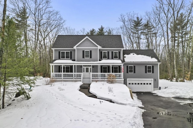 colonial inspired home featuring covered porch, driveway, and an attached garage