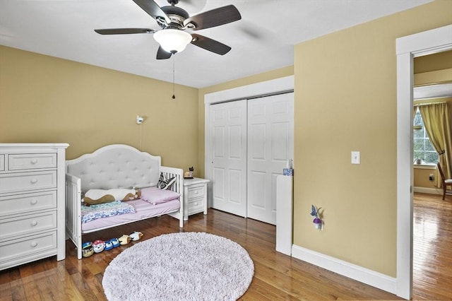 bedroom with a ceiling fan, a closet, baseboards, and wood finished floors