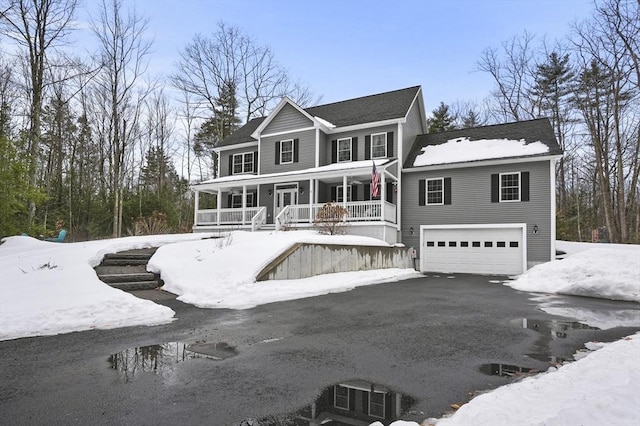 view of front of property with a garage, a porch, and aphalt driveway