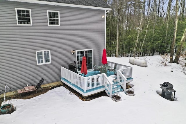 snow covered house featuring a deck and a shingled roof