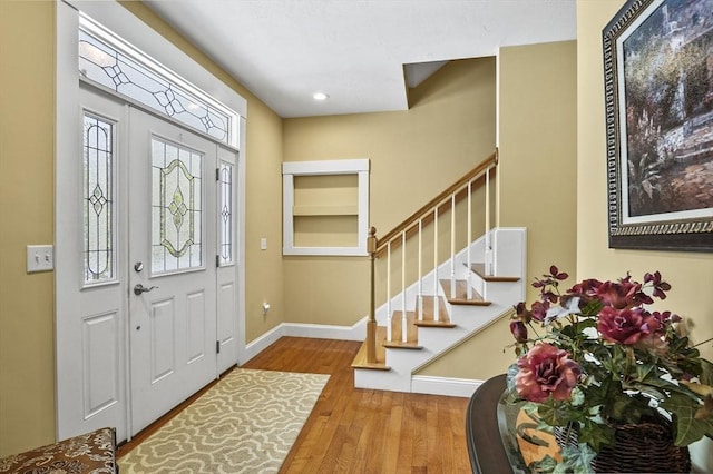 entrance foyer featuring stairs, recessed lighting, wood finished floors, and baseboards