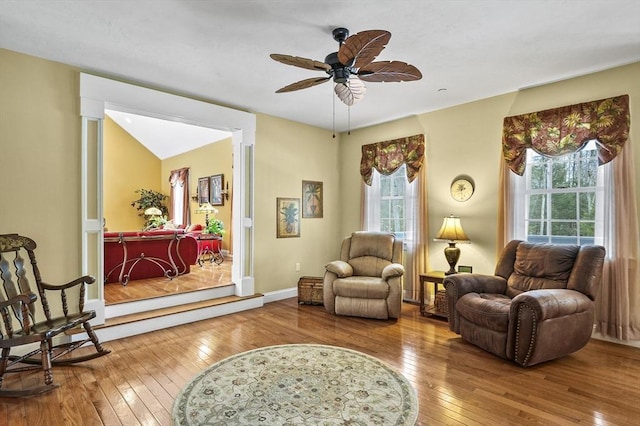 sitting room with hardwood / wood-style floors, a ceiling fan, and baseboards