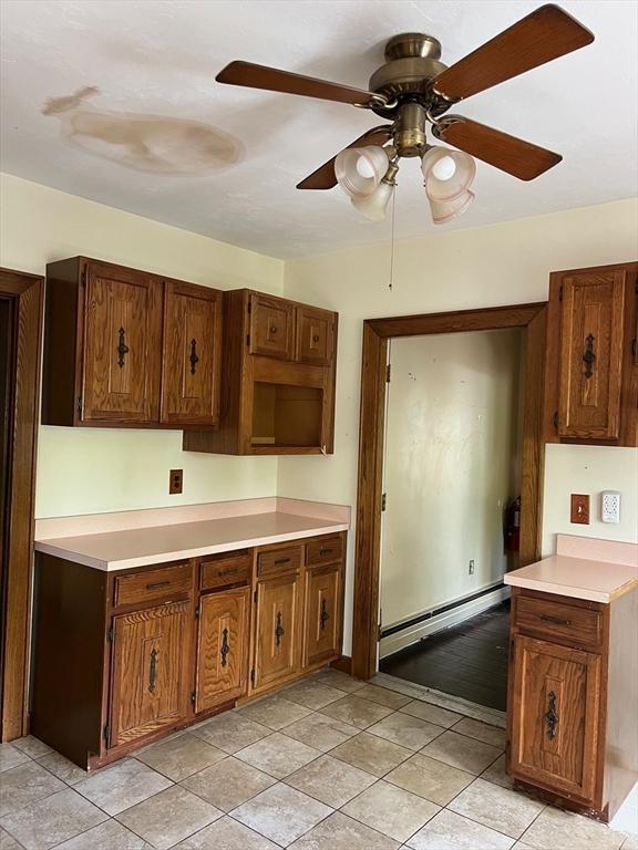 318 Holden St, Holden, MA 01520 - kitchen with a baseboard heating unit, ceiling fan, light countertops, and brown cabinetry