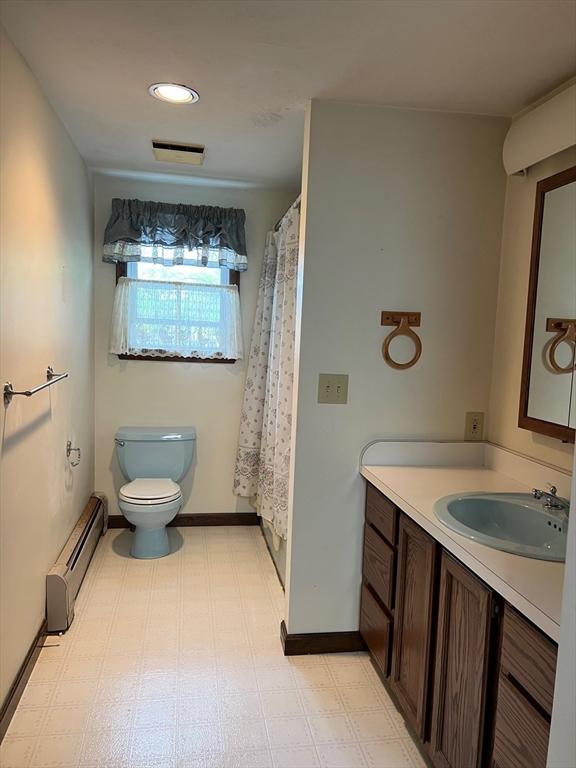 318 Holden St, Holden, MA 01520 - bathroom featuring a baseboard radiator, vanity, toilet, tile patterned floors, and a shower with shower curtain