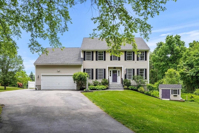 67 Hillside St, Rowley, MA 01969 - colonial home with asphalt driveway, an attached garage, and a front yard