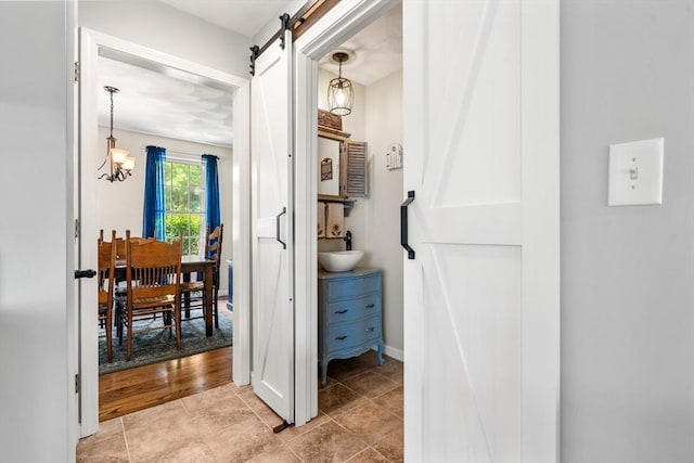 67 Hillside St, Rowley, MA 01969 - hall featuring a barn door, a chandelier, a sink, light tile patterned floors, and baseboards