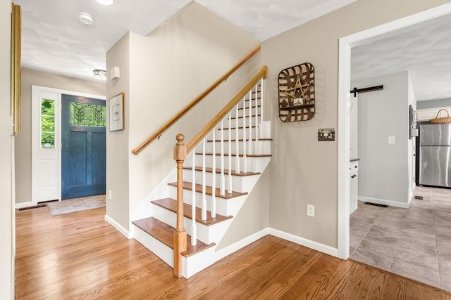 67 Hillside St, Rowley, MA 01969 - stairway with a barn door, wood finished floors, and baseboards