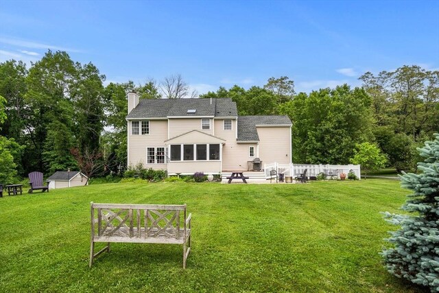 67 Hillside St, Rowley, MA 01969 - rear view of property featuring a chimney, a yard, a sunroom, and a patio