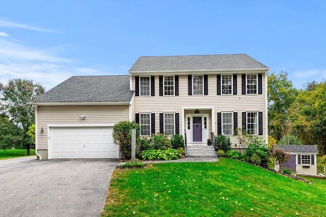 67 Hillside St, Rowley, MA 01969 - colonial house featuring asphalt driveway, a front lawn, and a garage