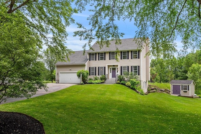 67 Hillside St, Rowley, MA 01969 - colonial home featuring an attached garage, a front lawn, driveway, roof with shingles, and a chimney
