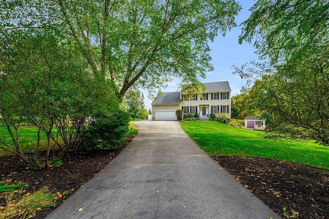 67 Hillside St, Rowley, MA 01969 - colonial-style house with a front yard, asphalt driveway, an attached garage, and an outdoor structure