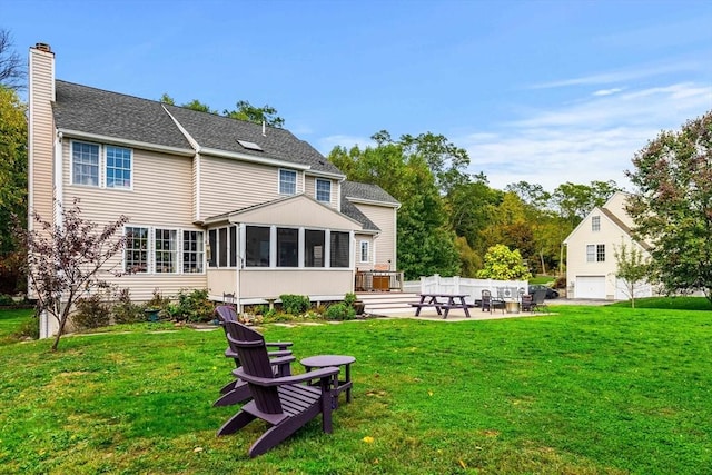 67 Hillside St, Rowley, MA 01969 - back of property with a chimney, a sunroom, a patio, and a lawn