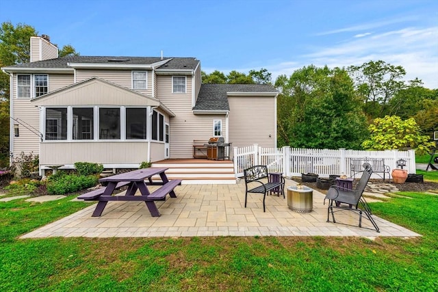 67 Hillside St, Rowley, MA 01969 - rear view of property featuring a sunroom, a patio area, a chimney, a deck, and a fire pit