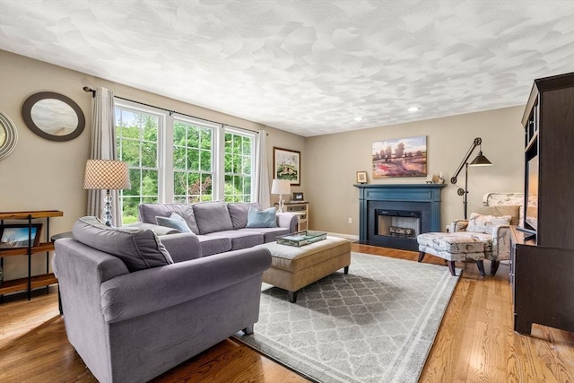 67 Hillside St, Rowley, MA 01969 - living area with a fireplace with flush hearth, wood finished floors, and a textured ceiling
