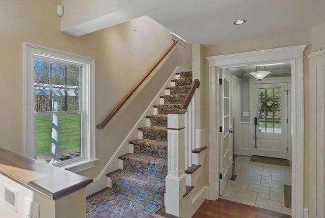 staircase with recessed lighting and stone tile flooring