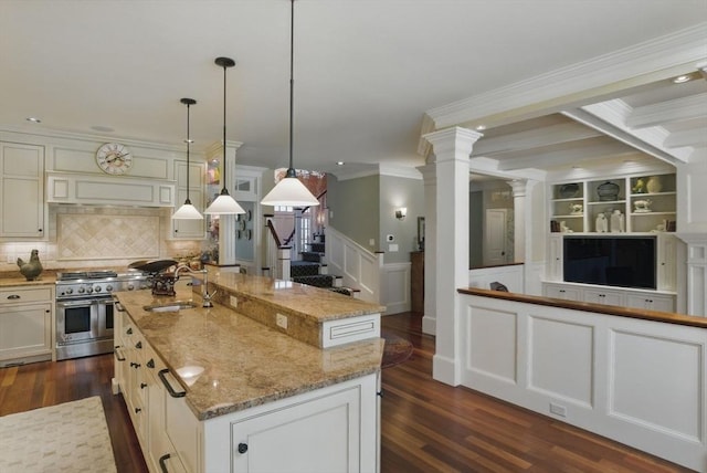 kitchen featuring a sink, a center island with sink, double oven range, dark wood-type flooring, and ornamental molding