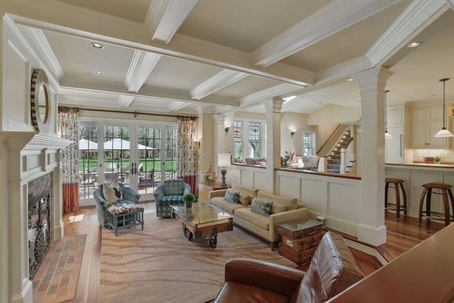 living room featuring ornate columns, coffered ceiling, crown molding, and beam ceiling