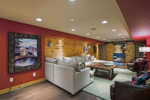living area featuring recessed lighting, a barn door, wood finished floors, and visible vents