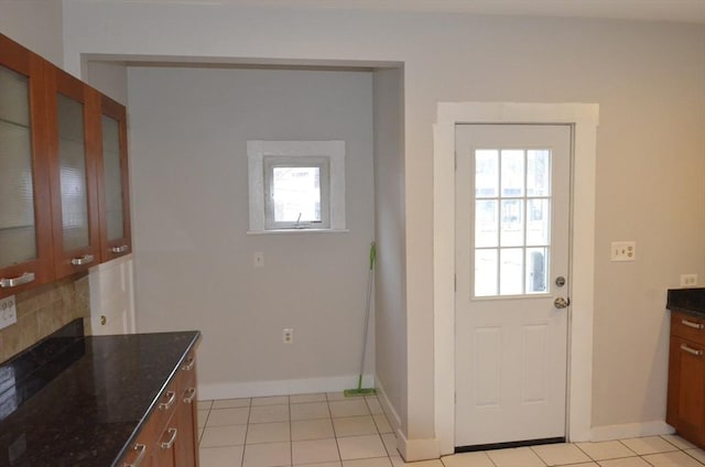 entryway with light tile patterned flooring and baseboards