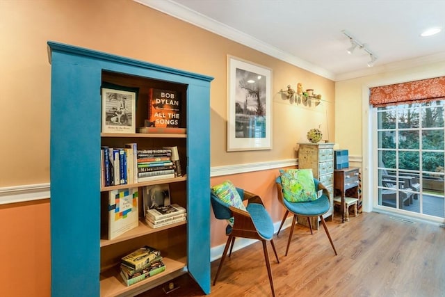 sitting room with ornamental molding, rail lighting, and hardwood / wood-style floors