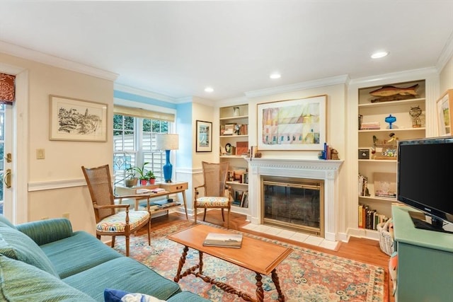 living room featuring crown molding, built in shelves, and light hardwood / wood-style floors