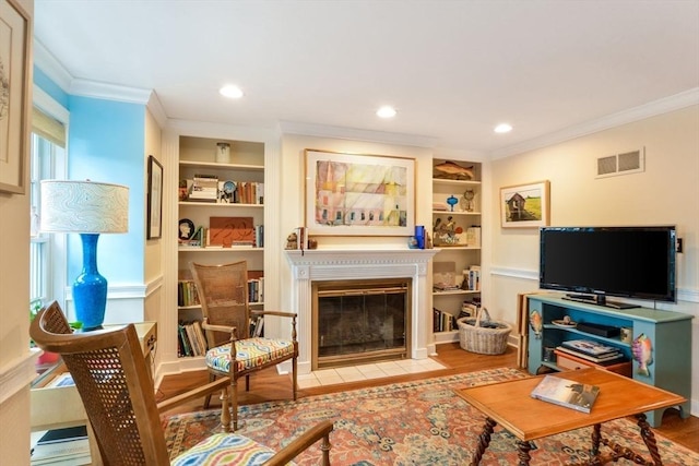 living room featuring ornamental molding, built in features, and light wood-type flooring