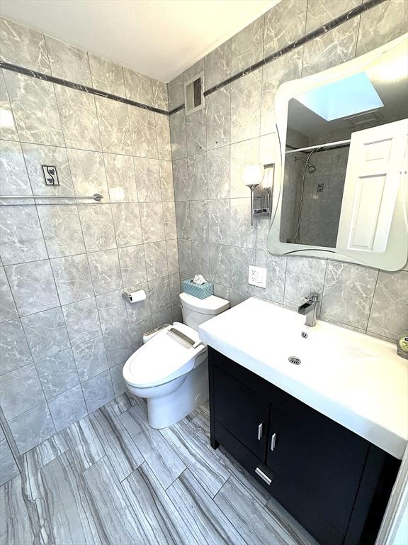 59-R Union St Unit 59-R, Boston, MA 02135 - bathroom with tile walls, vanity, toilet, a tile shower, and tasteful backsplash