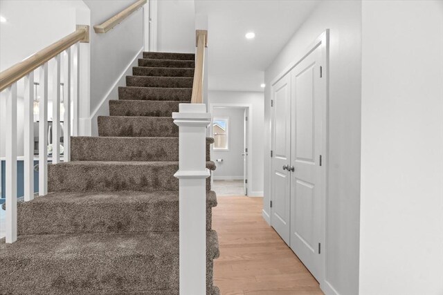 stairway featuring recessed lighting, wood finished floors, and baseboards