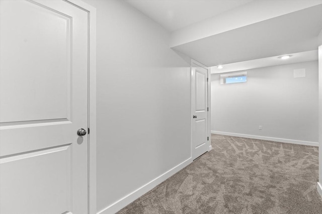 basement featuring carpet flooring and baseboards